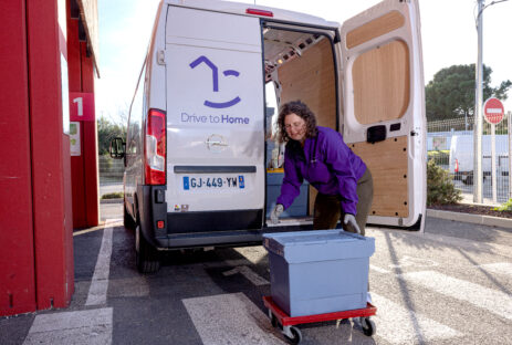 Messagère Chauffeuse-Livreuse qui charge les courses dans le camion Drive to Home